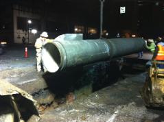 Crew lowers pipe into trench