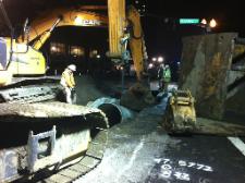 Workers carefully place pipe to make connection to another section of pipe.