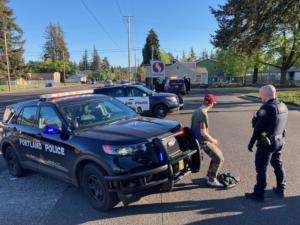 suspect_detained_seated_on_bumper.jpg